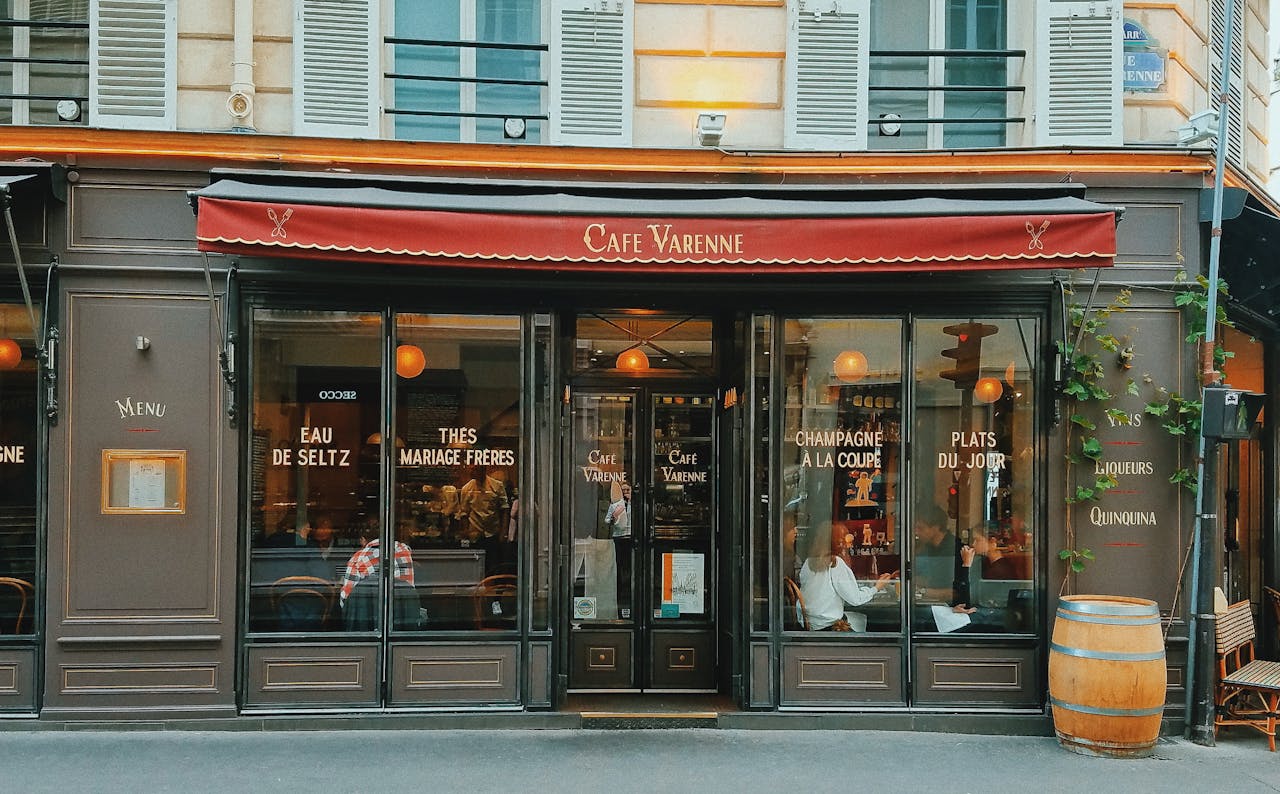 Parisian cafe storefront with classic architecture and red awning.